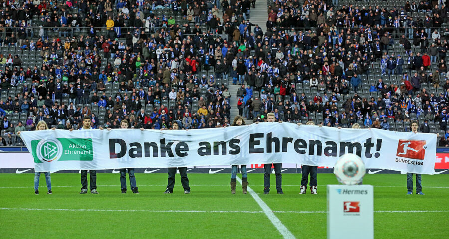 DFB Ehrenamt - Ein Banner wird von Jugendlichen im Stadion hochgehalten